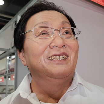 一个戴眼镜和白衬衫的老先生微笑着。