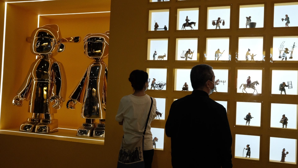 一些人站在一个有机器人图片的墙前