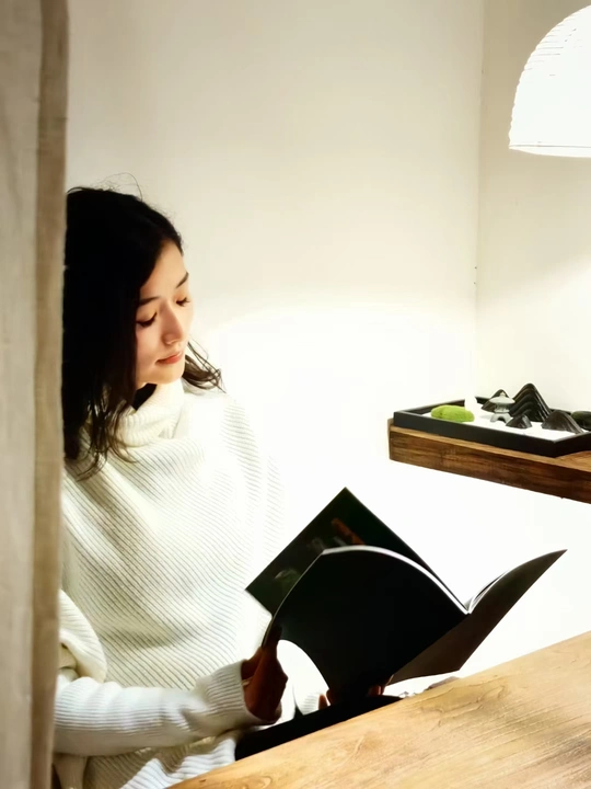 一个年轻女子坐在桌子旁读书