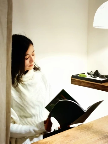 一个年轻女子坐在桌子旁读书