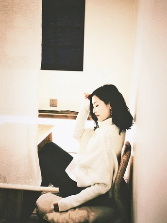 一个年轻女子坐在白色房间里的长凳上