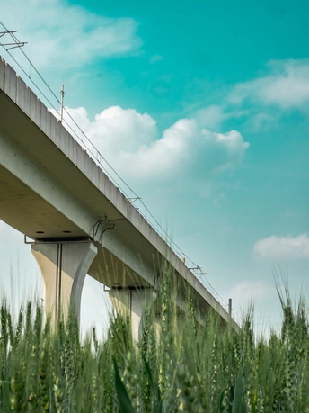 高速公路上的绿色草地和蓝色天空下的桥
