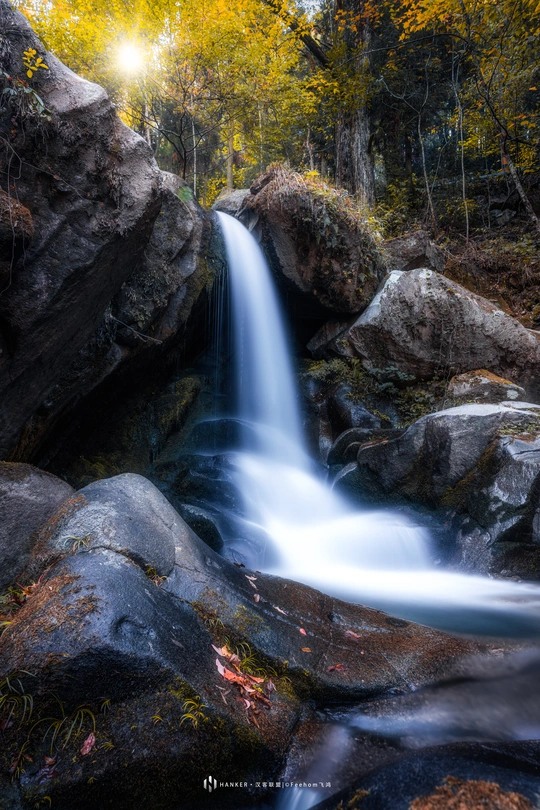 森林中的一小股瀑布 阳光透过岩石洒下