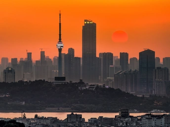 太阳正在落山 背景是城市天际线和前景建筑。