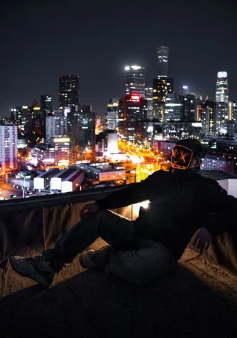 夜晚俯视城市的屋顶上的男人