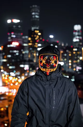 一个戴面具的男子站在夜晚的屋顶上