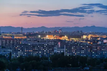 夕阳或黄昏时分的城市和背景中的建筑与山峦