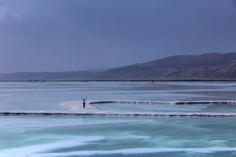 一个站在覆盖着冰的蓝色湖上的男人