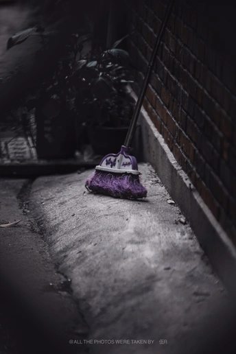 一把紫色的雨伞放在建筑物旁边人行道上的枕头上