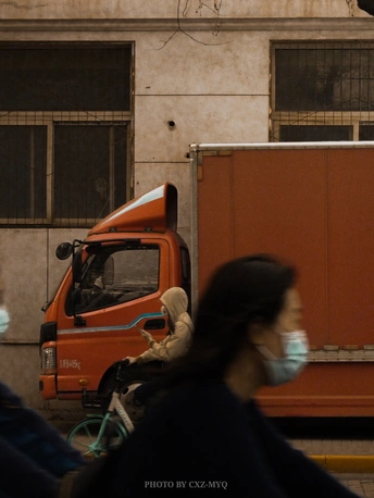 人们戴着口罩走在卡车前面