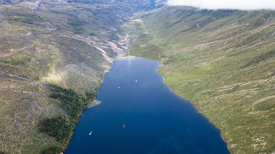 一张被群山和水体包围的湖泊的照片