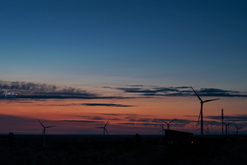 风车场中的日落 前景中有风车 太阳在地平线上落下