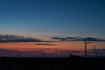风车场中的日落 前景中有风车 太阳在地平线上落下