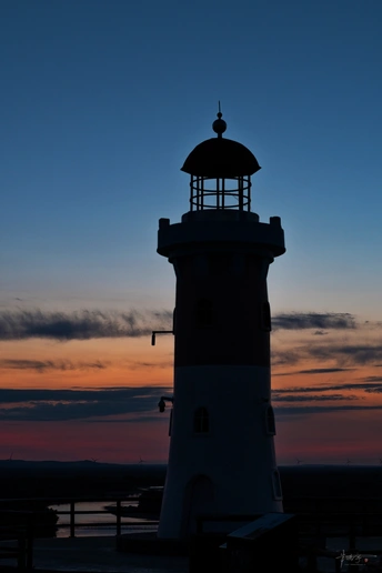 夕阳下或黄昏时灯塔 太阳照亮天空