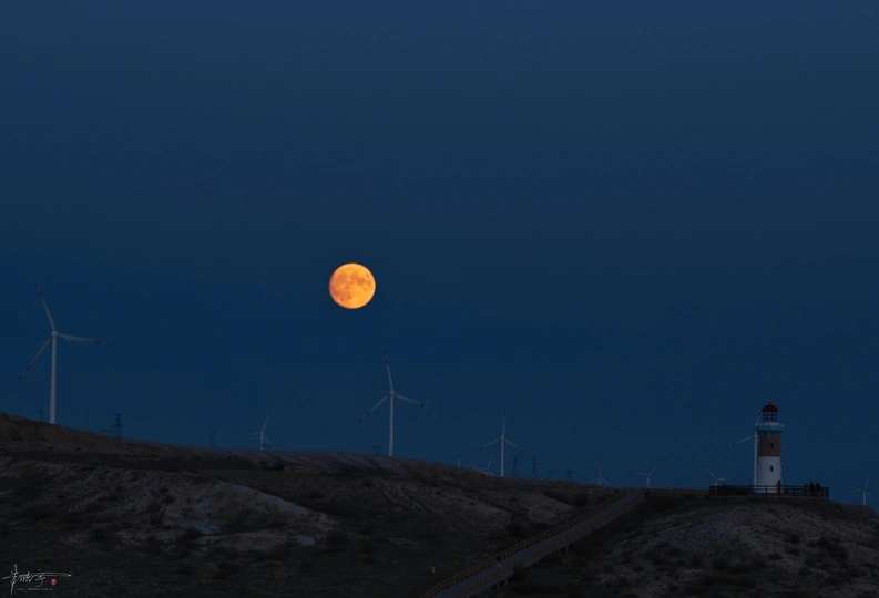 月亮升起在山顶的灯塔上