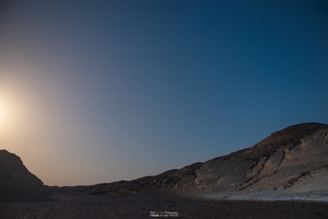 夜晚沙漠上升的满月 天空中繁星闪烁。