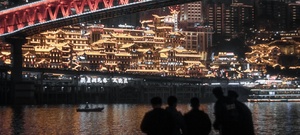 一些人在桥下站着 晚上看着一座被点亮的城