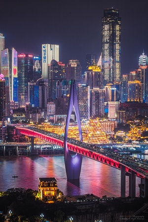 夜晚的摩天大楼和河上的桥照亮了城市