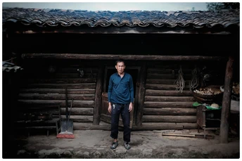 站在一所小木屋前面的一个男人