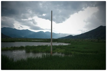 湖中一座杆子上的十字架 背景是山和云天