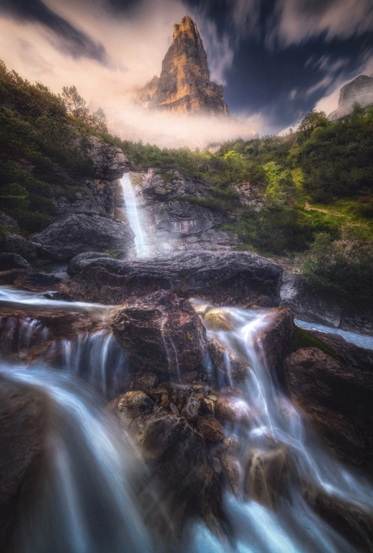 瀑布 背景是岩石和山脉 有戏剧性的天空