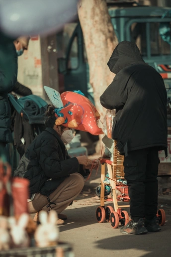 一个人戴着帽子在靠近手推车和人群的街道上