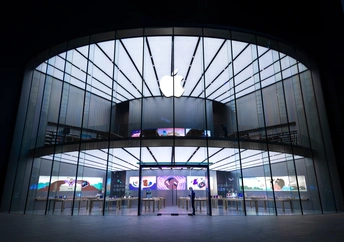 一个人站在一座大型建筑物入口处 夜晚被照亮了。