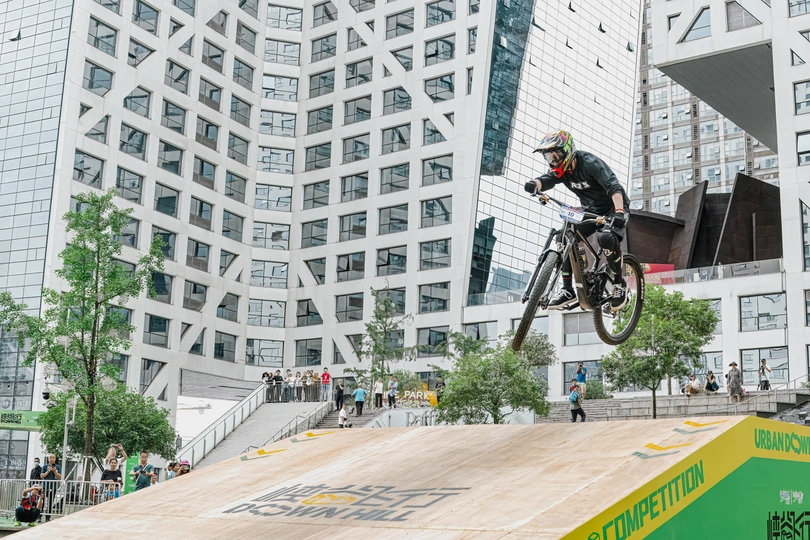 一个男人在骑自行车在城市中跳跃一个跳台