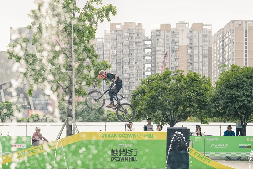 一个男人在城市的公园里骑自行车飞跃一个跳跃。