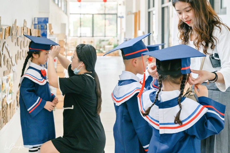 一群戴着帽子、穿着长袍的毕业生摆出姿势拍照