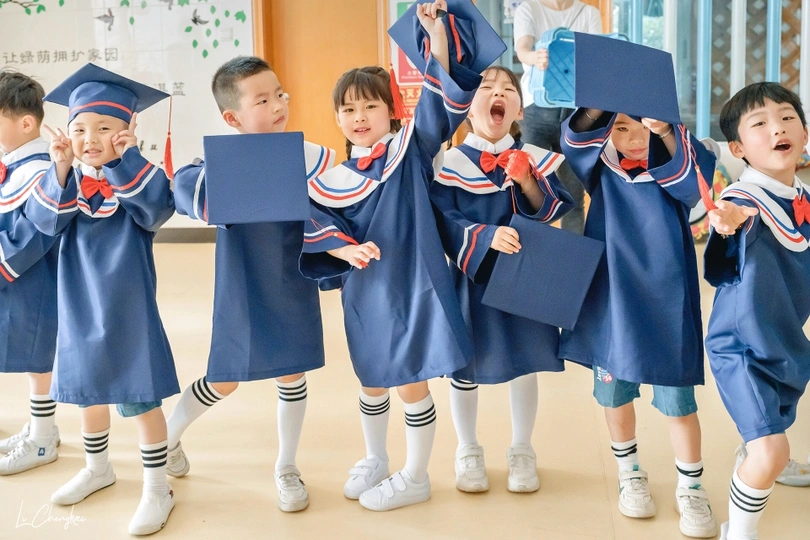 一群穿着长袍、拿着书的孩子庆祝毕业