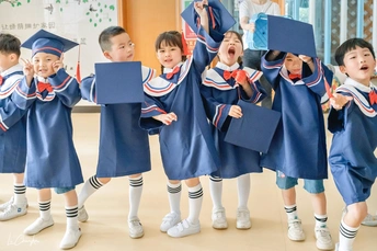 一群穿着长袍、拿着书的孩子庆祝毕业