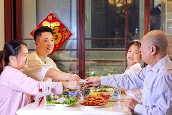 一个在餐厅里为一家坐在桌子上的家庭服务食物的男子。