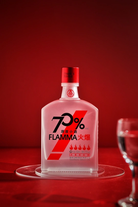 一瓶伏特加酒旁边放着一杯红葡萄酒。