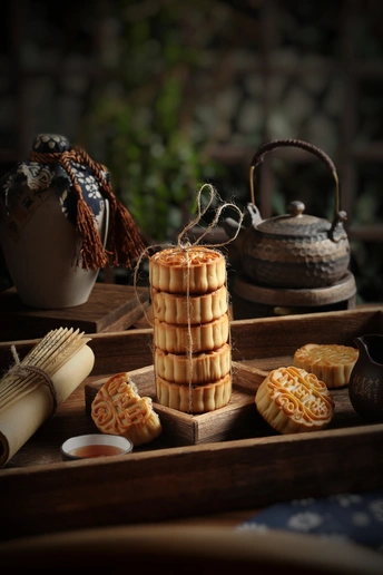 一个木制桌子 上面放着一个托盘 托盘上放着一些小甜点 还放着茶。