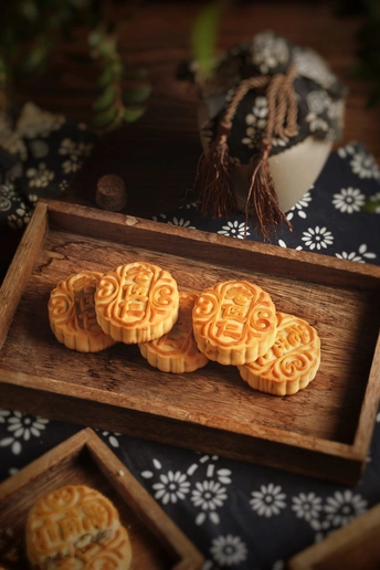 一个木托盘 上面放着一份甜点盘和一盒饼干。