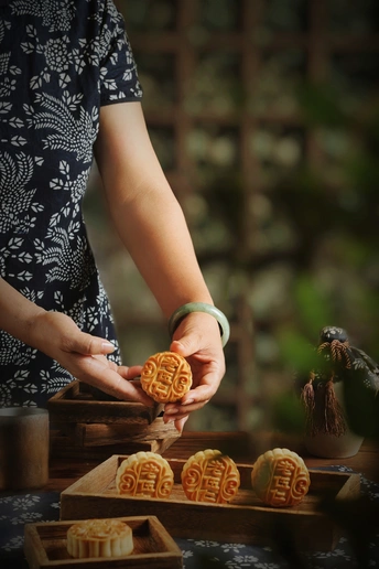 一个 woman 手上有几块饼干在木桌上