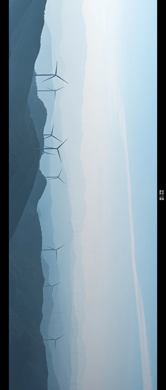 几座风车在水面上方的天空中剪影