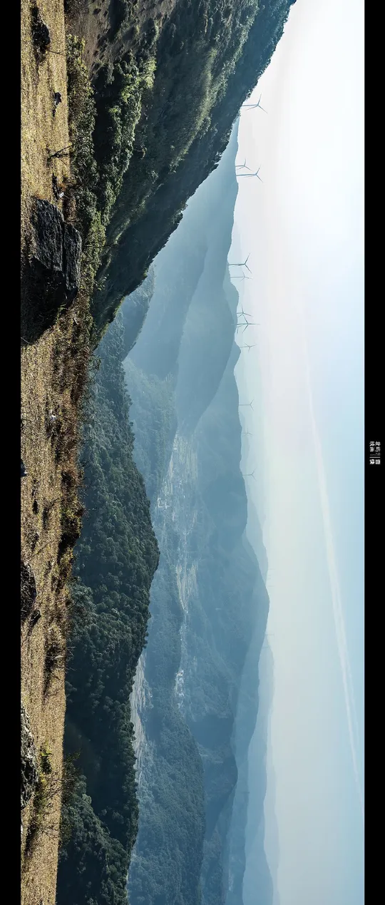 一条长船在大片水域旁靠近陡峭的悬崖