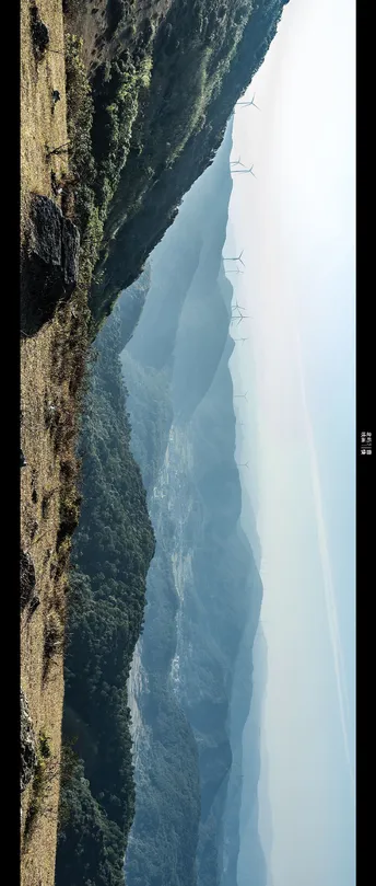 一条长船在大片水域旁靠近陡峭的悬崖