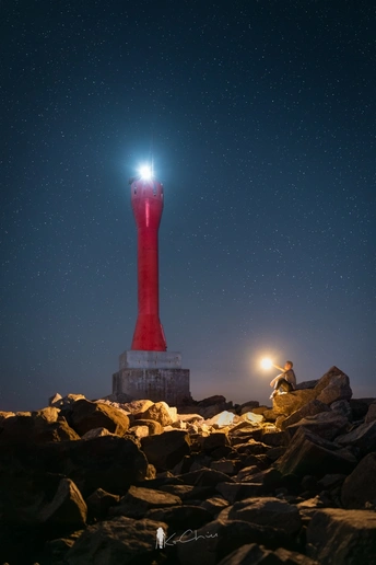 一个红色的灯塔在夜晚被星光照亮 巨石上闪耀着光芒。