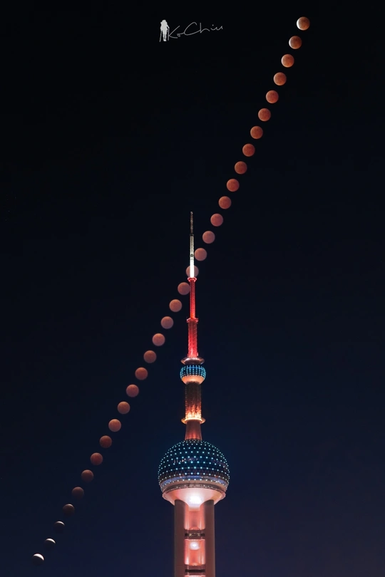 夜晚中一栋高塔被月亮照亮了。