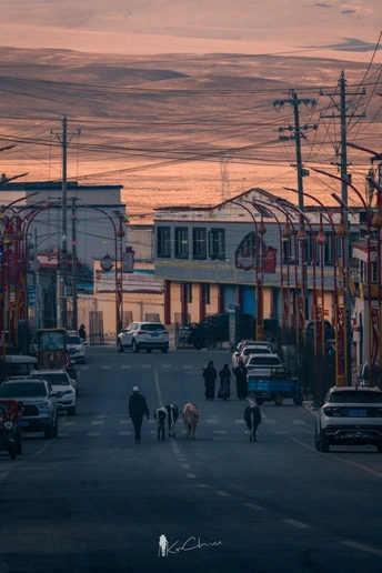 夕阳下的城市街道 人们漫步 汽车在公路上行驶。