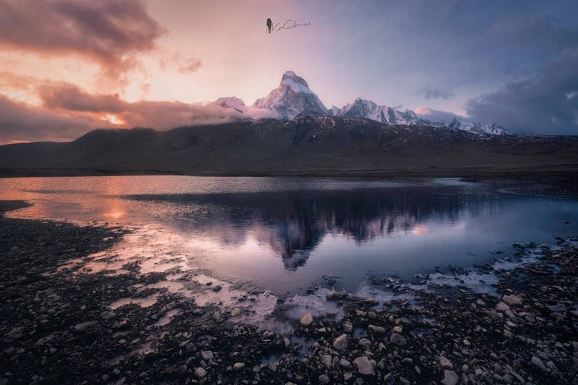 湖中倒影着山峦的湖泊和天空中飞翔的鸟。