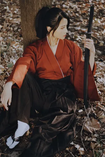 一位穿着和服的女子坐在森林中的一棵树下