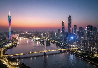 夜晚的城市 有河流、桥、天际线和被夕阳照亮的高楼。