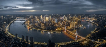 夜晚照亮的大型城市 前景是河流。