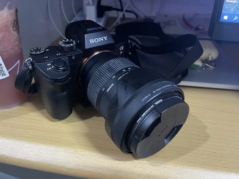 桌子旁边放着一个杯子里的饮料 一台相机正在桌子上