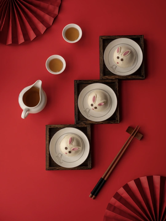 一个红色的墙 上面放着一个小托盘茶和咖啡 还有一只猫在盘子上。