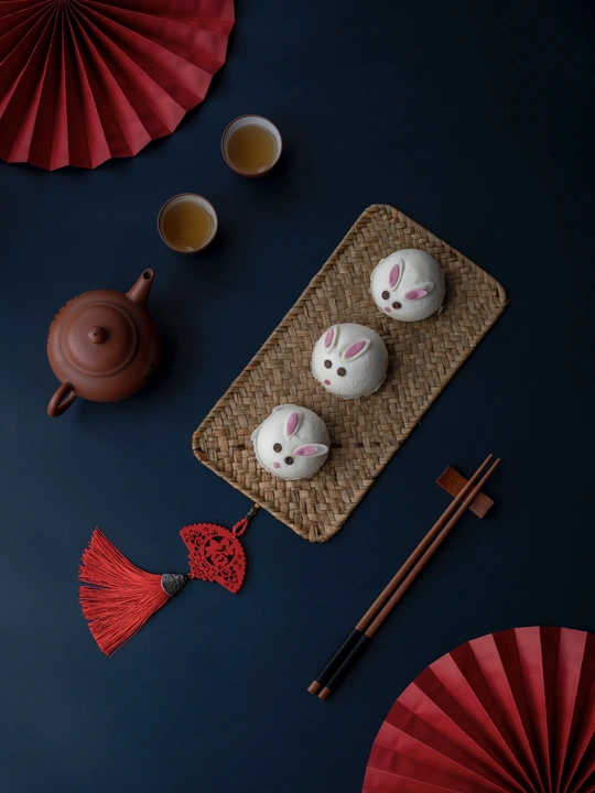 一张桌子 上面放着一些茶杯和一把红色的伞。